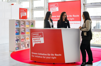 The exhibition's information counter booth with brand-focused design, modern setup, and professional staff interaction