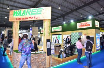 Waaree booth at The Smarter E India exhibition showcasing solar technology products and attracting visitors.