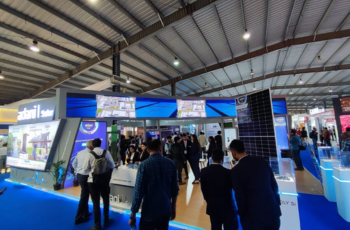 Overview of a bustling exhibition floor with multiple booths and attendees at The Smarter E India event.